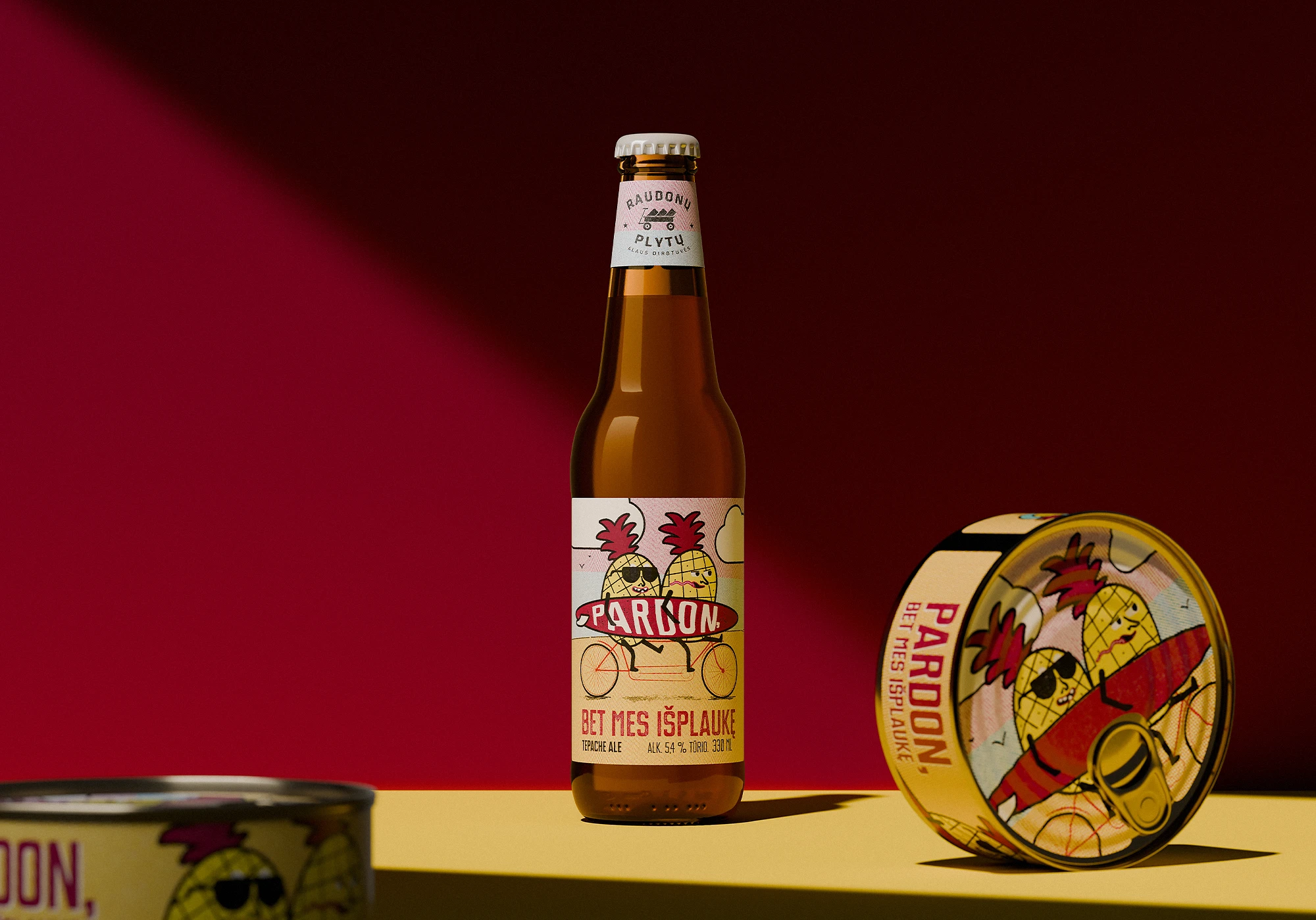 Bottle of “Pardon, bet mes išplaukę” beer with illustrated label showing pineapples on a bike, next to a matching tin can containing socks with the same design, set against a vivid red and yellow backdrop.