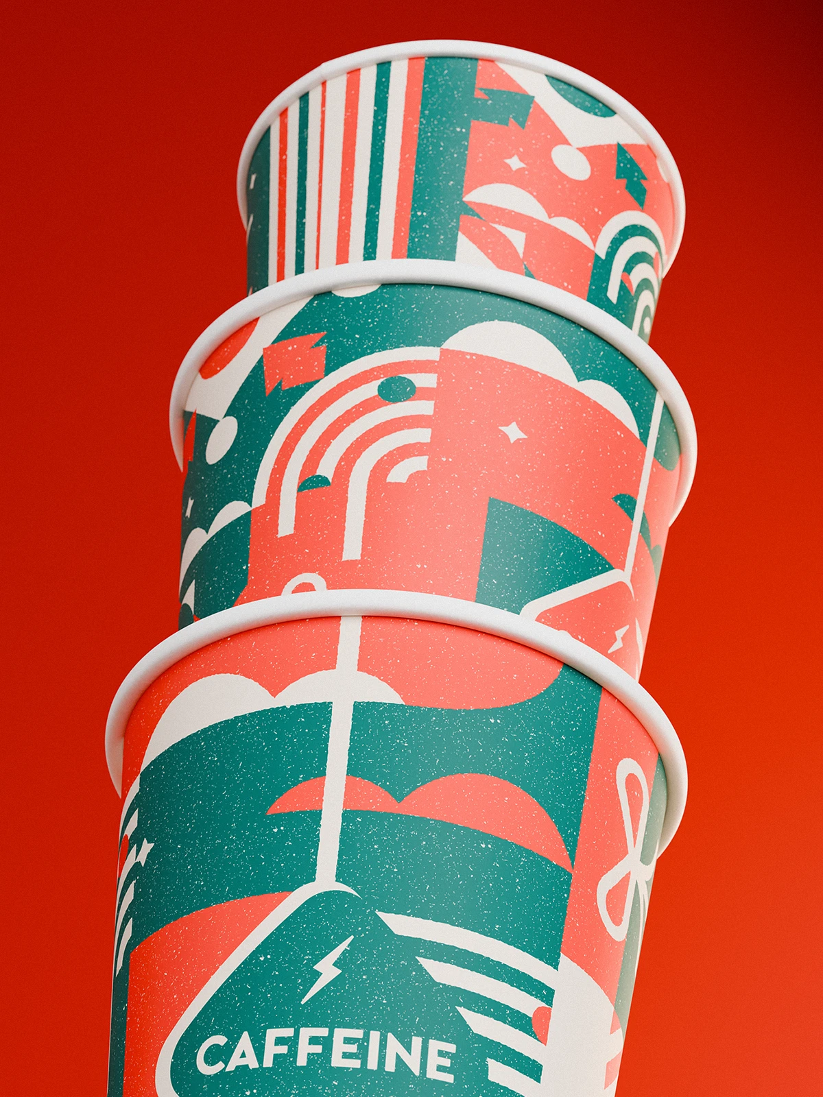 Stack of three festive paper coffee cups with red and green geometric holiday illustrations, including rainbows, stars, and gift shapes, featuring the “CAFFEINE” logo, against a solid red background.