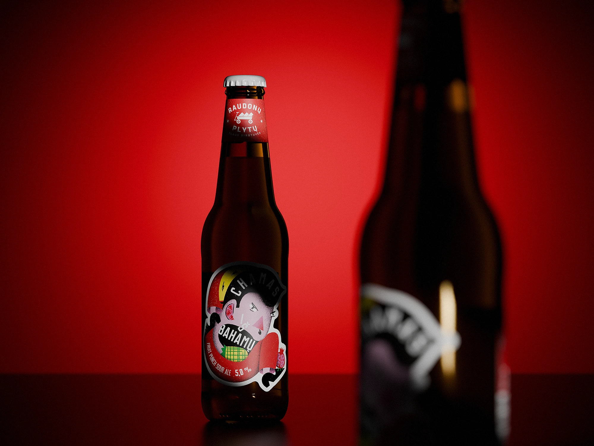 Beer bottle of “Chamas iš Bahamų” fruit punch sour ale standing on a glossy surface against a deep red background. The label shows an angry-looking illustrated character with fruit graphics. A second, blurred bottle appears in the foreground on the right, partially blocking the view.