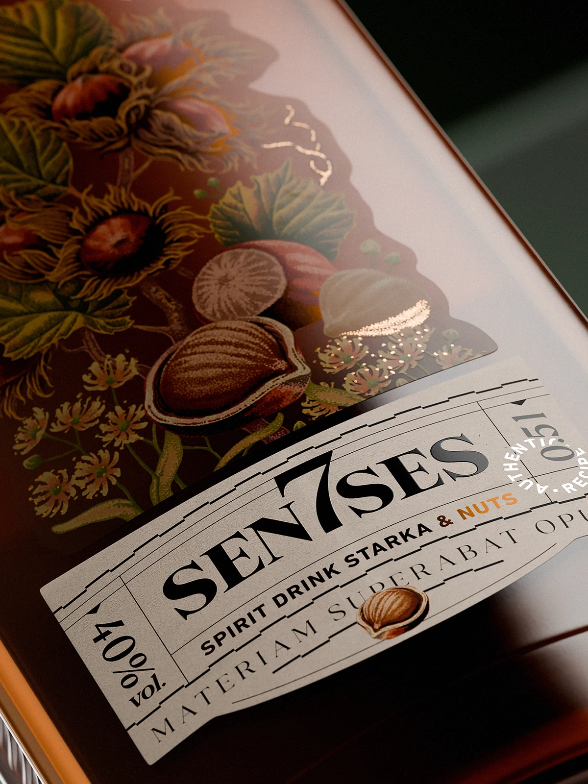 Close-up of a 7Senses Starka & Nuts bottle label on amber glass, with a curved white paper label reading “SEN7SES – Spirit Drink Starka & Nuts, 40% vol.” and a detailed hand-drawn illustration of hazelnuts, leaves, and flowers above it, accented by subtle metallic highlights and soft reflections on the glass.