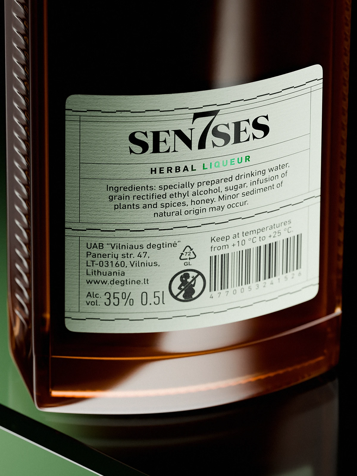 Back label of a 7Senses Herbal Liqueur bottle on amber glass, shown in close-up, with a pale green curved label featuring the “SEN7SES” logo, ingredients text, alcohol percentage, barcode, and regulatory icons, photographed with soft directional light and shallow depth of field.